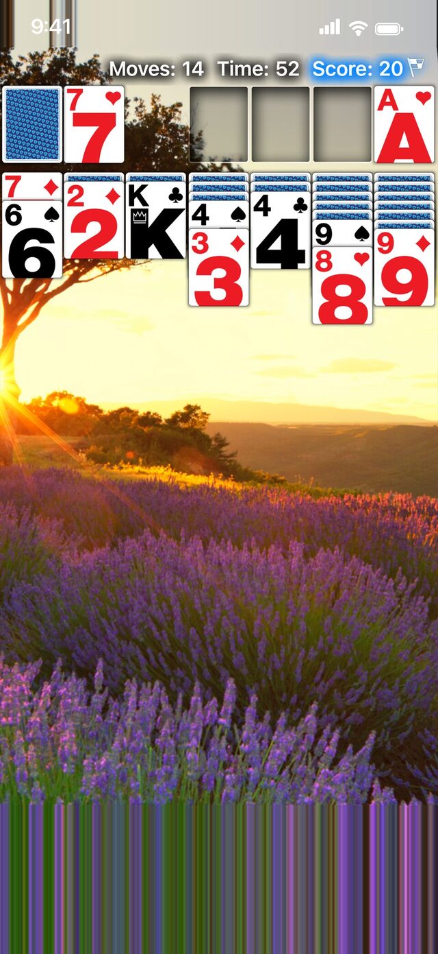 Real Solitaire on iPhone with Modern cards over a photo of a lavender field at sunset.