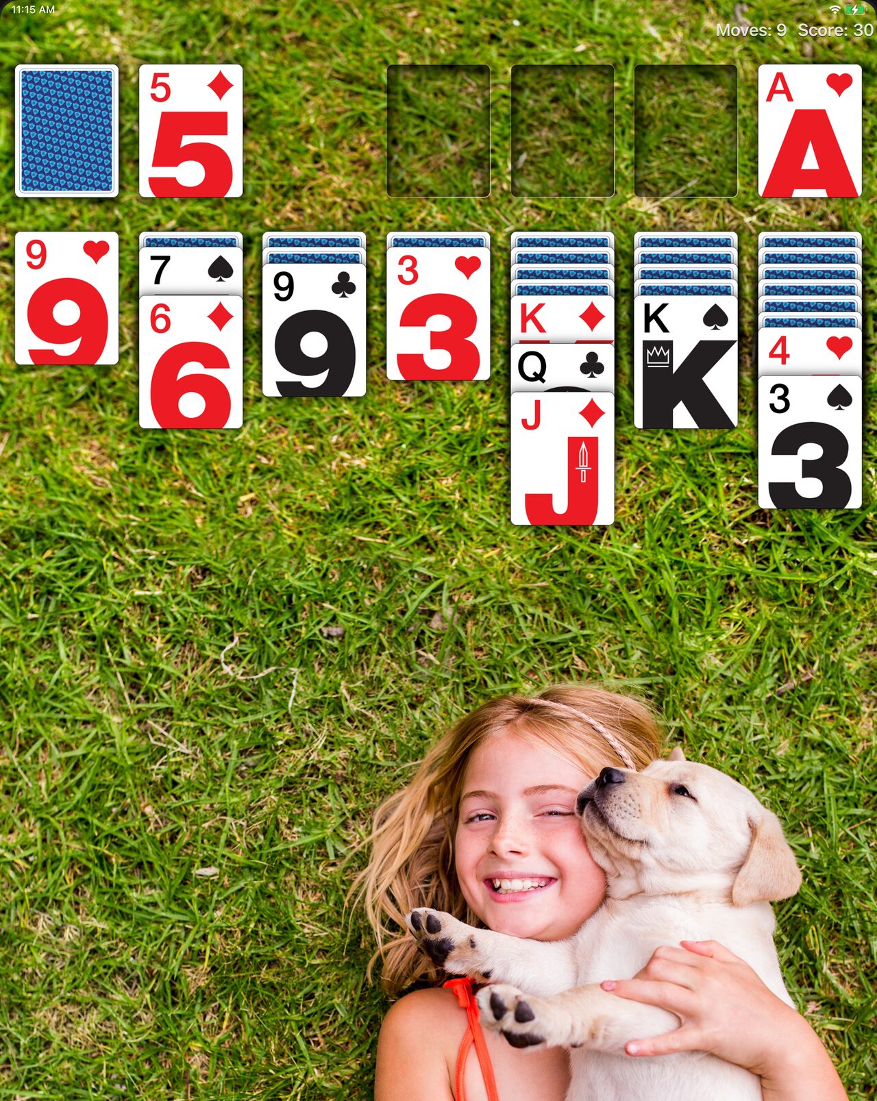 Real Solitaire on iPad with a personal photo, a girl hugging a puppy, as the wallpaper.