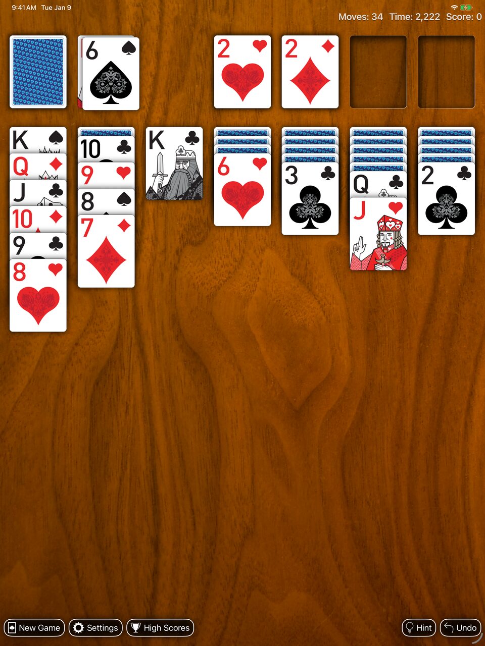 Real Solitaire for iPad: a game in progress with Royal cards and the Royal Blue back on the wood table.